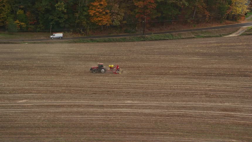 Aerial view of a tractor plowing a field in the countryside