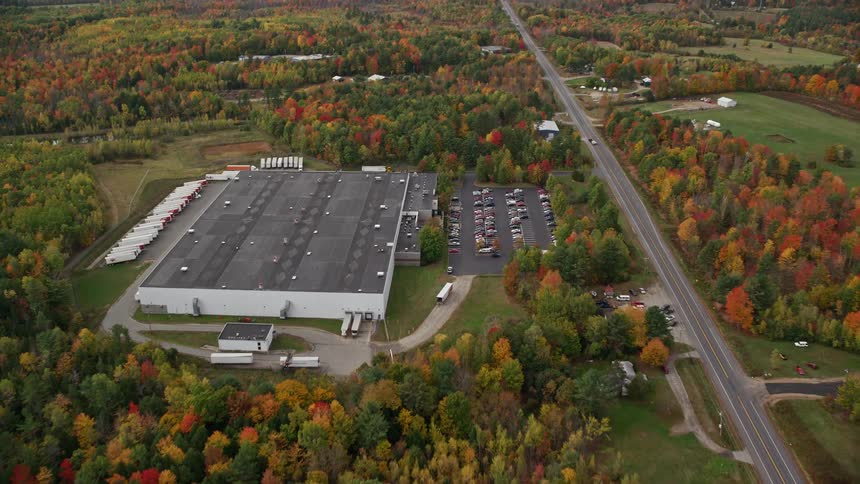 A large building with a parking lot full of cars next to it