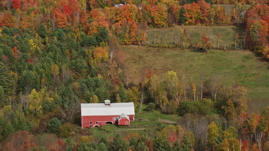An aerial panorama of a barn in the midst of a natural area