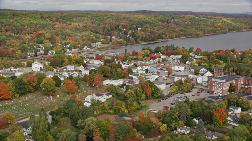 A suburban town with lots of trees around it and behind a huge lake