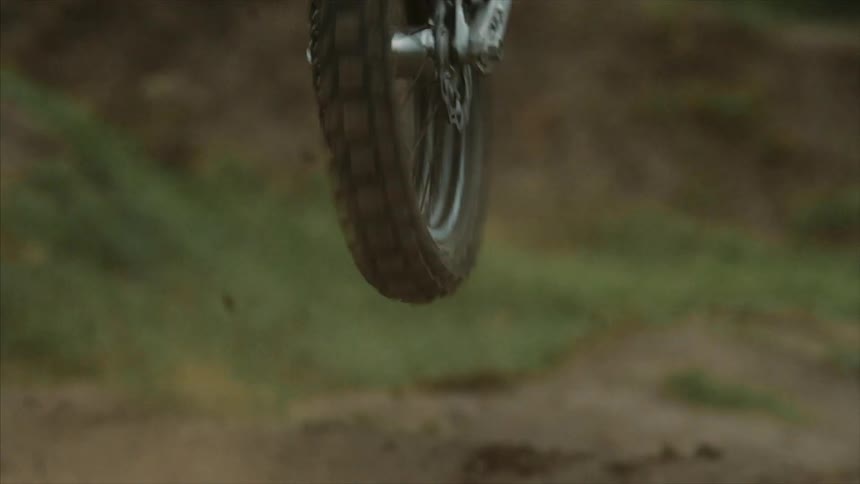 A man on a dirt bike makes a jump on a hill