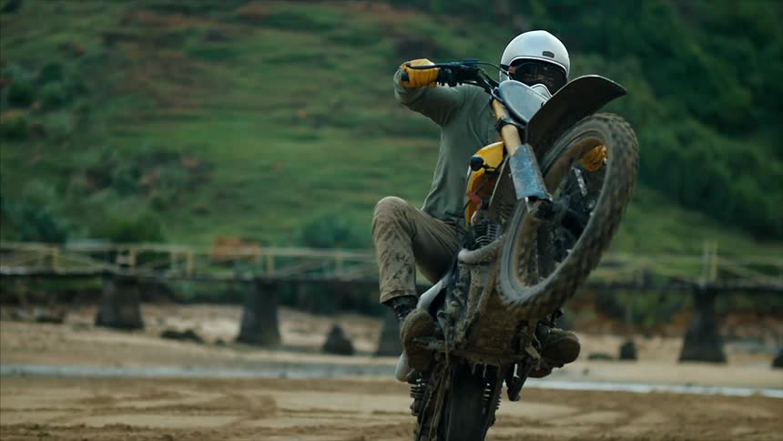 Motorcyclist riding a wheelie in the dirt