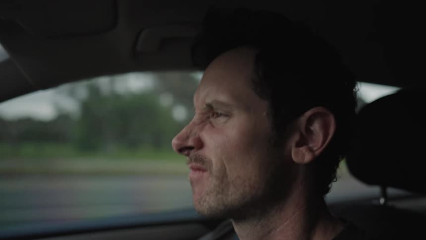 Closeup of a man driving and dancing with his head