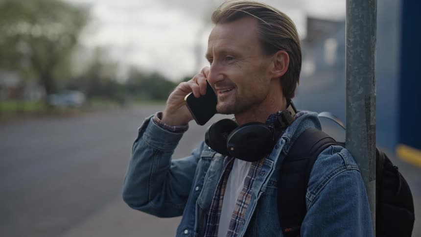 A blond adult man talking on cell phone and smiling