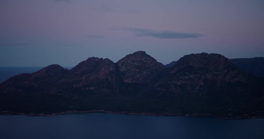 A huge mountain with three pigs and this mountain is facing the water