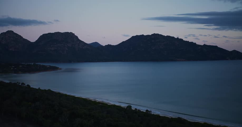 A big blue sea and behind huge mountains in one night