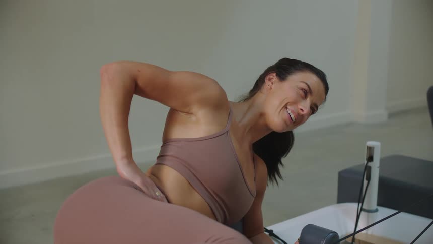 Woman stretching her legs on a pilates machine