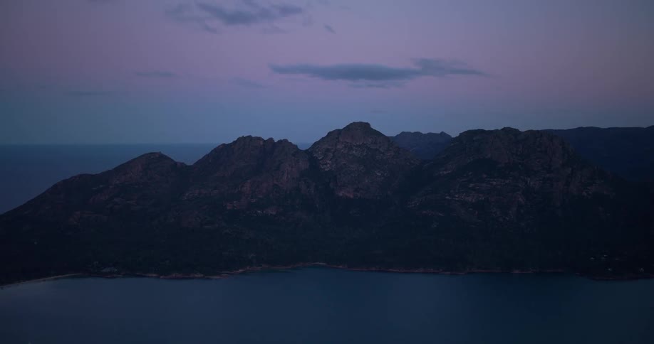 Aerial of a mountain island in the ocean during dusk