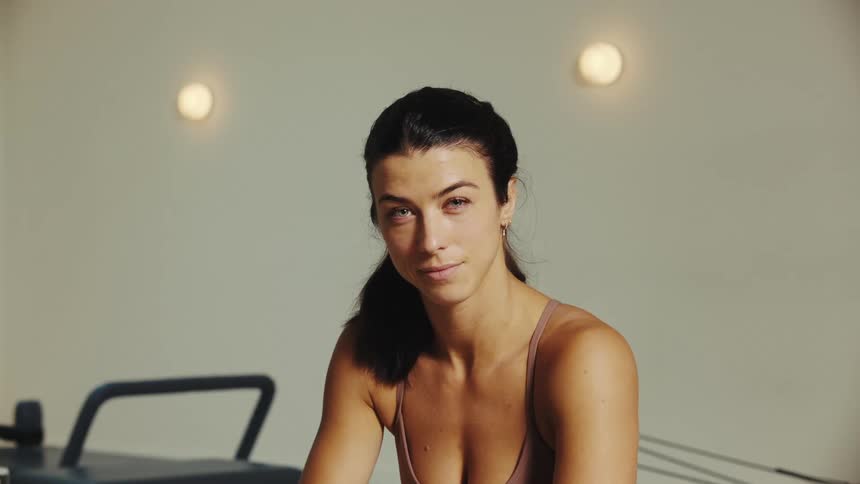A woman with light skin and dark hair is looking to her left side and then looks straight ahead