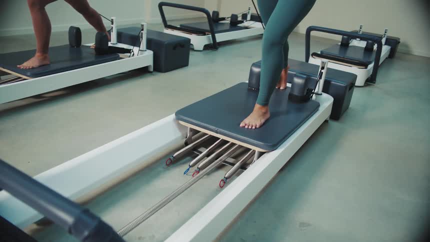 A concentrated woman doing exercises on a gym equipment