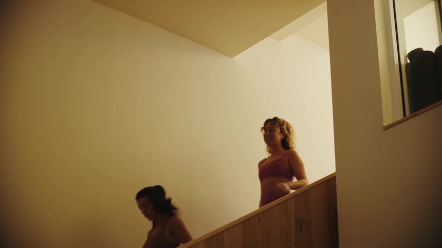Two women descending a staircase in a building