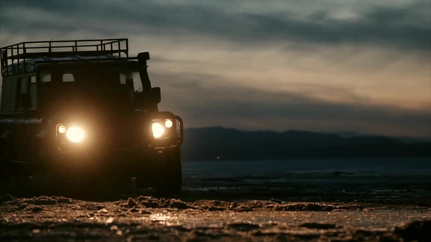 A truck is driving in the mud at dawn