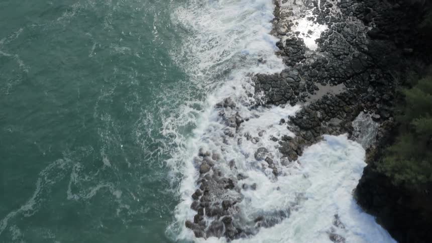 Waves crash against the rocks of the shore