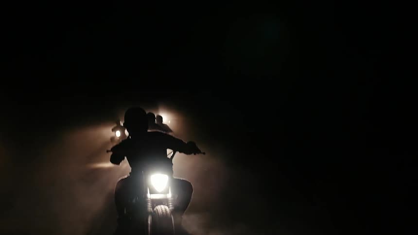A person rides a dirt bike at night