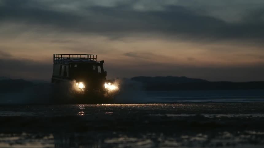 A truck speeds through the mud at dawn