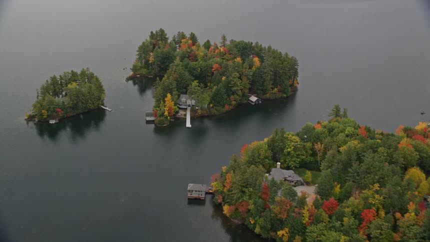 Aerial of buildings surrounded by trees built on the water