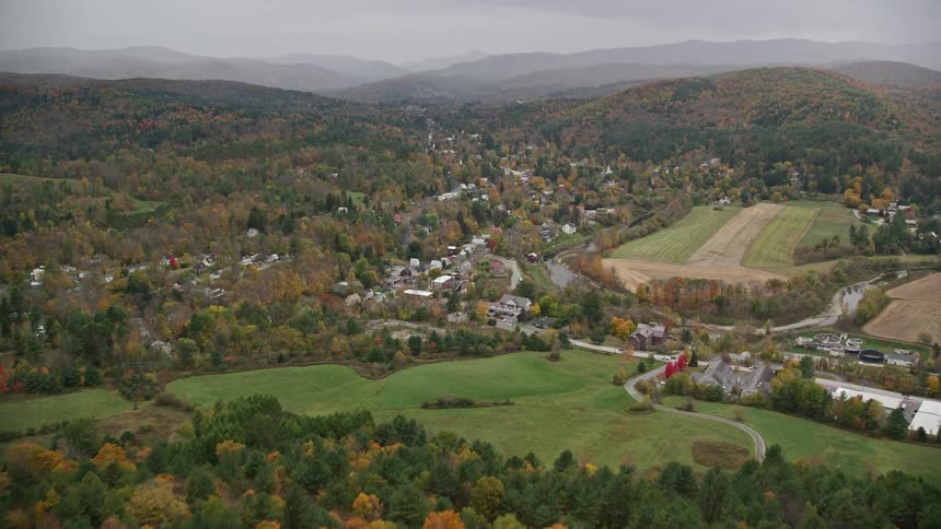 Aerial view of an autumn forest and a town near a river