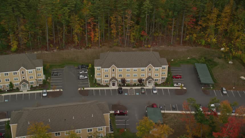 Aerial view of buildings in rural area surrounded by trees in fall color