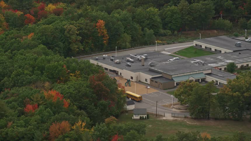 An aerial panorama of a school in the midst of an area with abundant vegetation