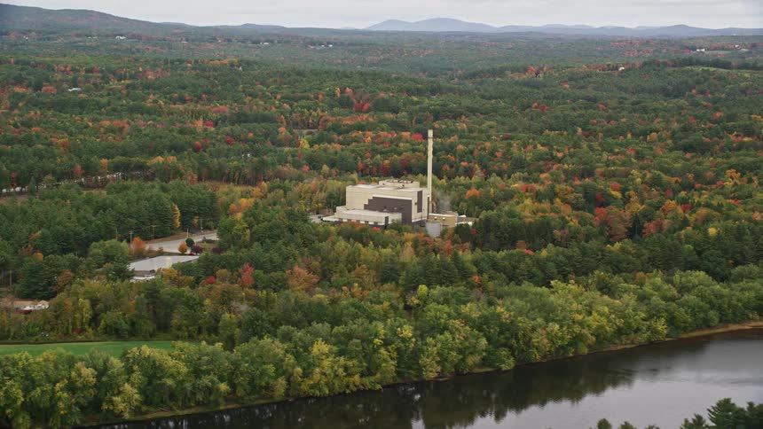 Skyline of a factory in the forest near the river