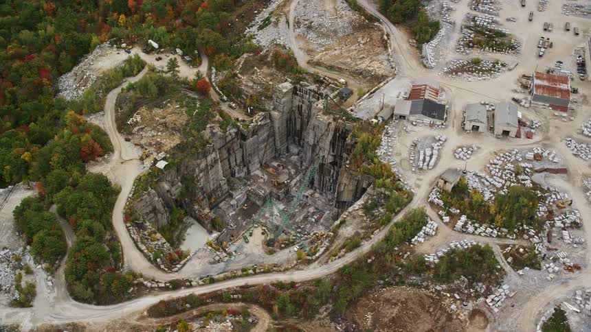 There are storage buildings at the top of the stone quarry