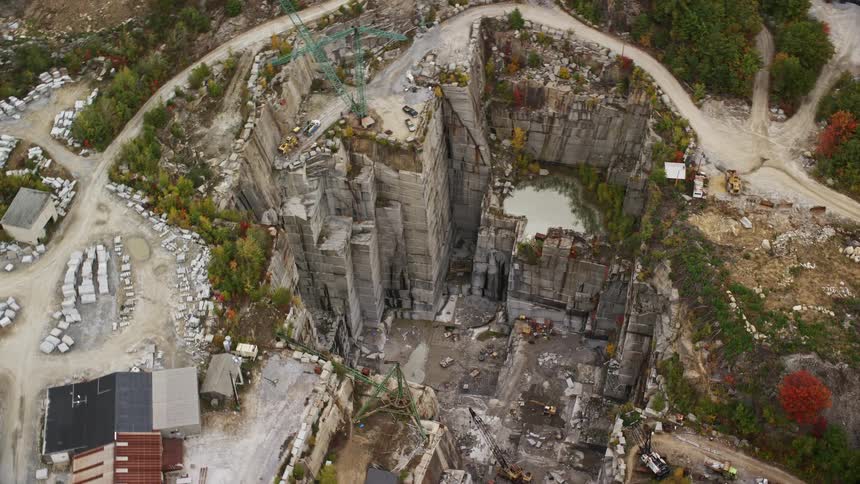A mine with a structure a mine hole and a crane with lots of rocks