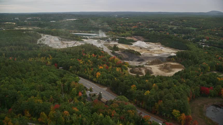 Aerial view of sand production by the side of a highway in the midst of a forest