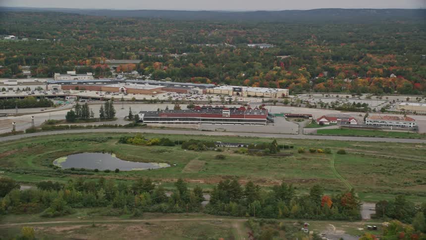 An aerial view captures rockingham park and its colorful autumn foliage under overcast skies in salem new hampshire