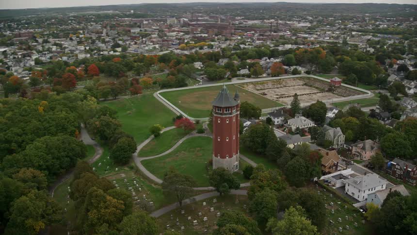 Aerial view of a central tower next to a cemetery in the midst of a residential town