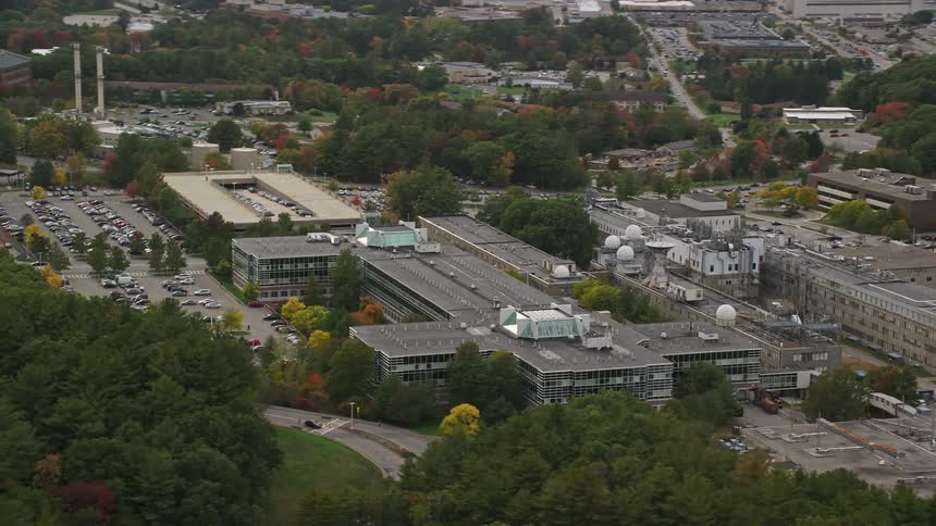 Several buildings in a suburb of a city with several trees behind