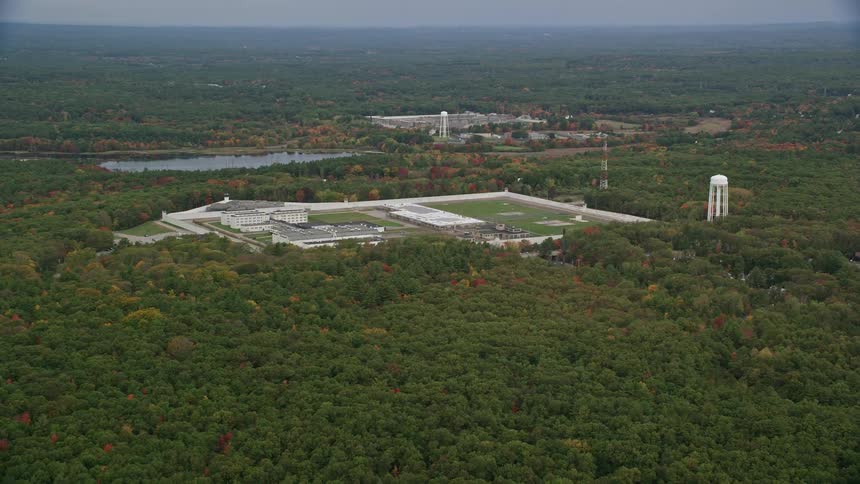 An aerial view captures trees with vibrant fall foliage near the massachusetts correctional institution cedar junction in walpole massachusetts