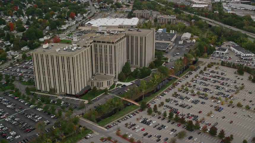Three building block in center of large parking lot on fall day