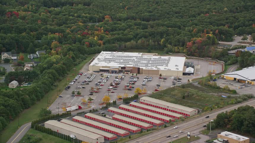 Aerial of the company with parking lot with forest in the background