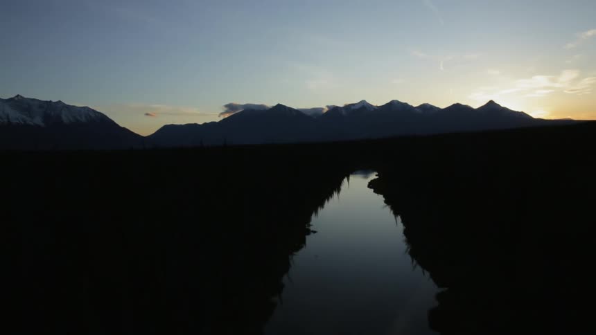 A small canal runs through this field at dawn