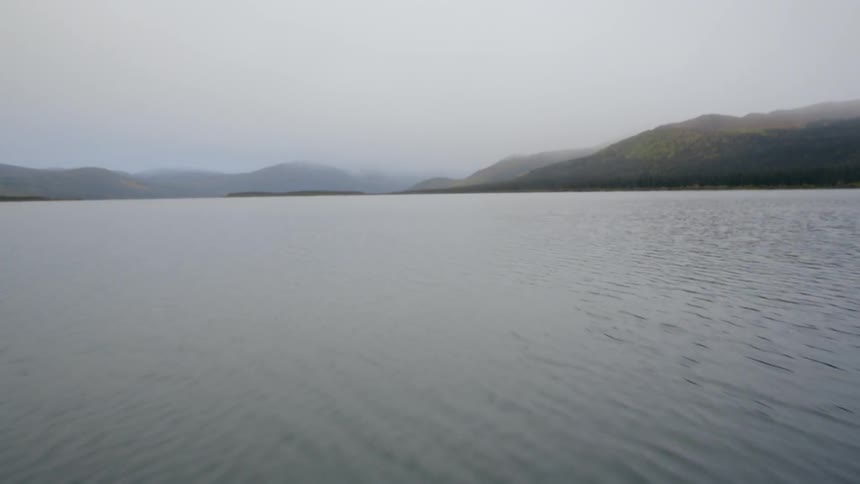 Moving fast across the water towards a mountain range ahead