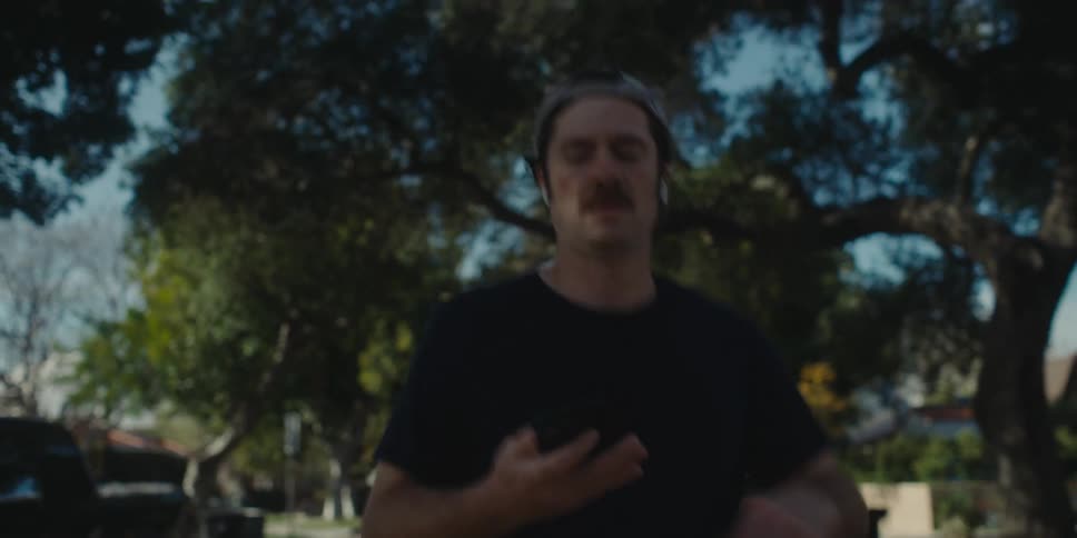 A man running in a neighborhood listening to music