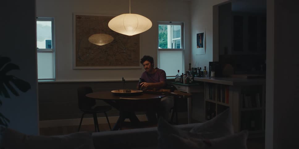 Man sitting at a table and eating with a facial expression of weakness