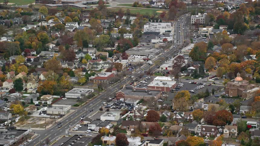 Aerial of a neighborhood with a main highway during the day