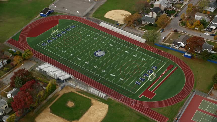 Aerial view of adjacent american football and baseball fields in a suburban town