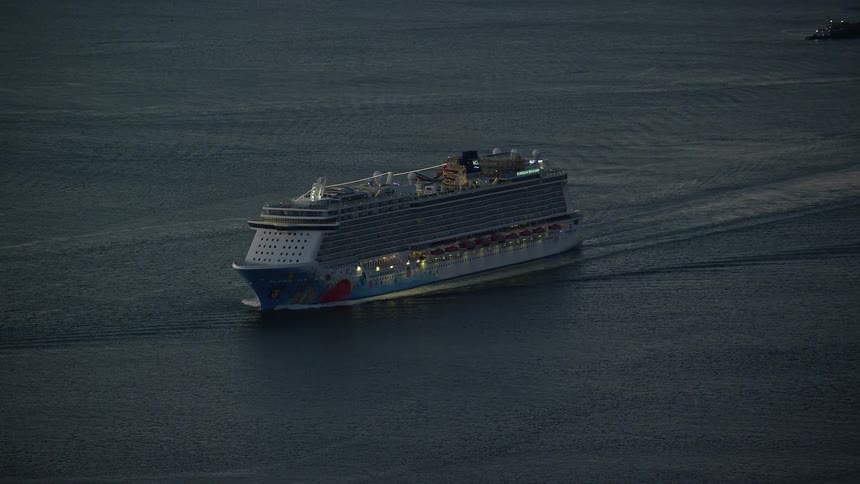 A massive cruise ship travels steadily across the ocean surface