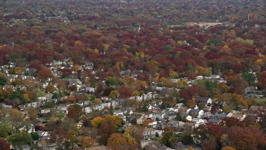 A suburban region of a small town with trees with red leaves