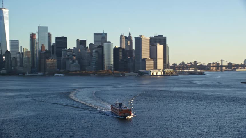 Cargo ship in motion on the sea with a metropolis in the background