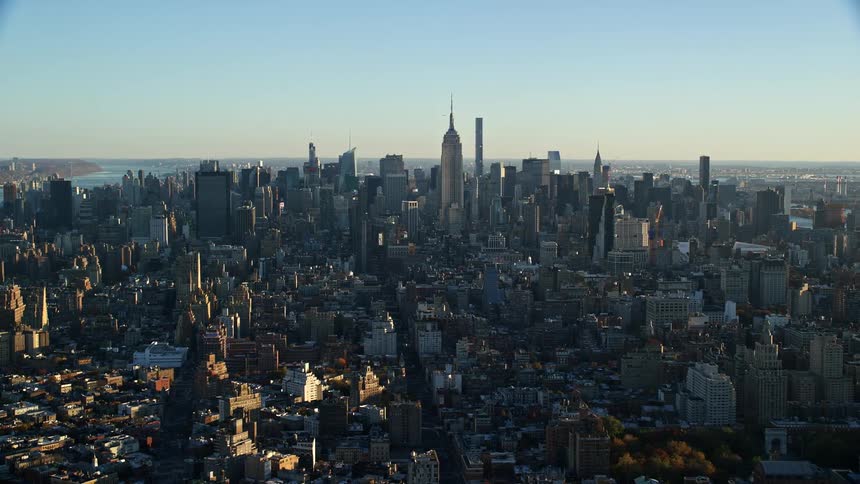 Aerial view of a metropolis by the sea under a dawn sky