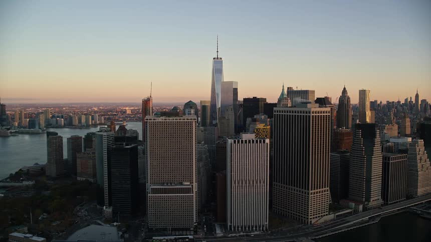 A metropolitan region with tall buildings on the coast of an island facing the water