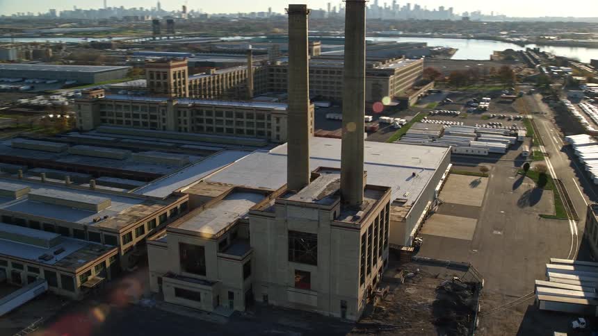 A factory with two smoke towers on the roof and a solar light