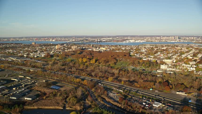 An aerial view of a city with lots of vegetation and a large river in the middle