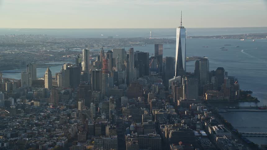 Aerial view of the lower manhattan skyline in new york city with the prominent one world trade center and the surrounding dense urban structures and the river in the background