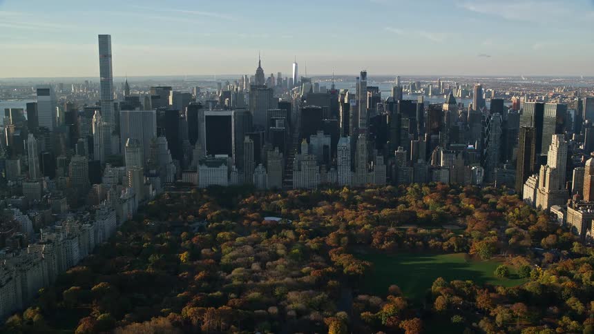 Aerial view of central park in new york city surrounded by dense urban landscape of skyscrapers and buildings