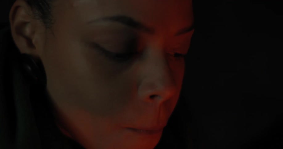 A woman drinks from a mug at night