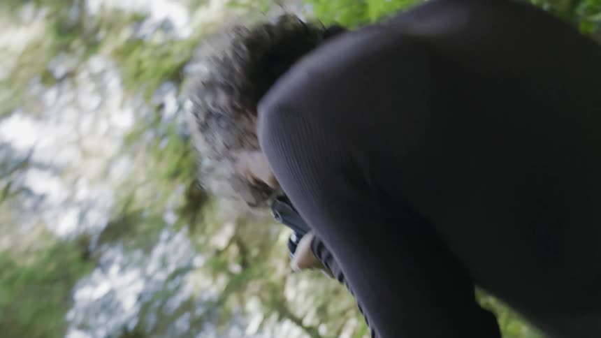 A person with a camera taking photos of a forest